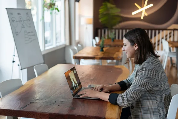 A woman sitting at a table with her laptop.