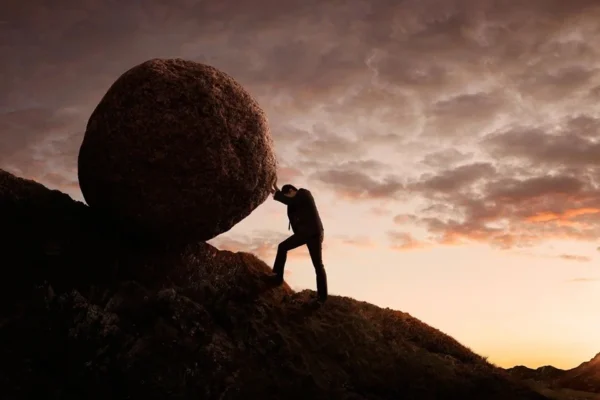 A person on top of a rock with a sky background