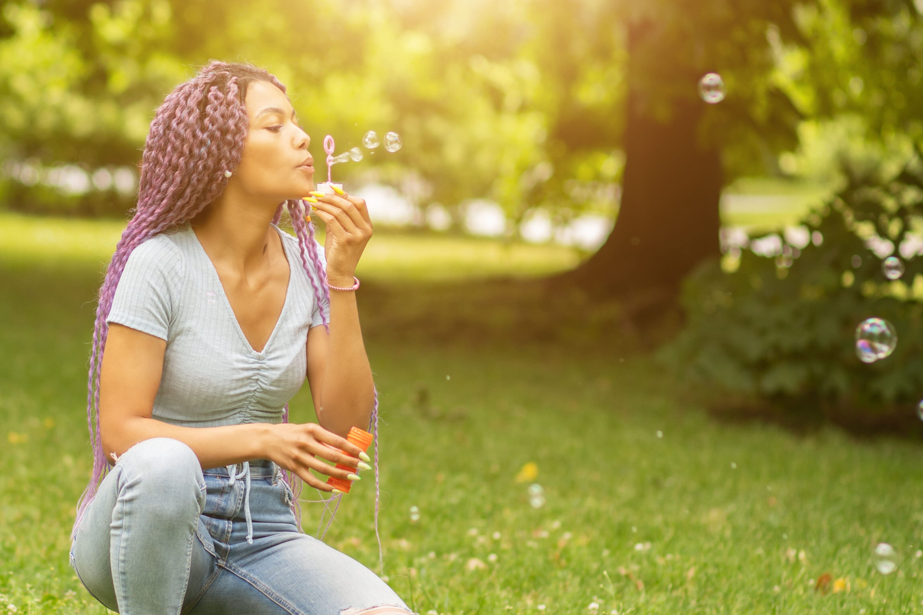 happy young afro american woman blowing bubbles in the park, outdoor recreation, outside vacation